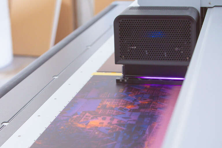 Der swissQprint Digitaldrucker des Fotolabor Trenkle Freiburg im Breisgau druck gerade ein Heimatfoto aus Schiltach im UV-Direktdruckverfahren