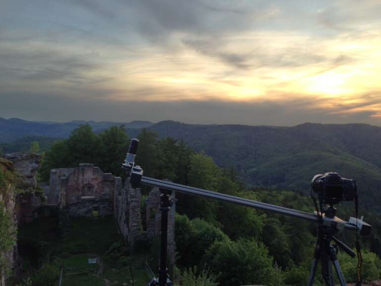 Kamera auf einem Slider steht an einem Aussichtspunkt bei einer Burgruine im Pfälzerwald und nimmt einen Zeitraffer / Timelapse auf.