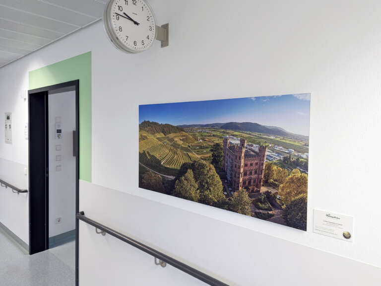 Wandbild von Heimatfotos zeigt eine Drohnenaufnahme des Ortenberger Schlosses bei Offenburg an einer Wand im Ortenau Klinikum